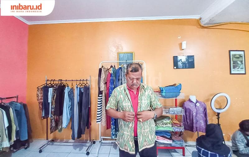 Seorang lelaki paruh baya tengah mencoba pakaian batik bekas di Preloved Sitas LRC-KJHAM. (Inibaru.id/ Fitroh Nurikhsan)