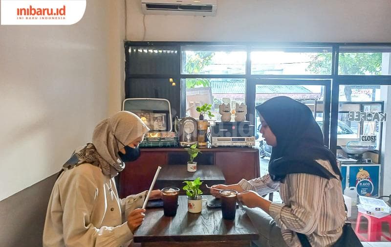 Dua orang pengunjung sedang menikmati secangkir kopi di kedai kopi Kaofee. (Inibaru.id/ Fitroh Nurikhsan)