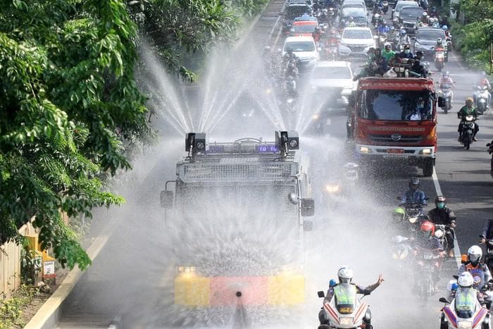 Penyemprotan cairan disinfektan di jalan. (Antara Foto).