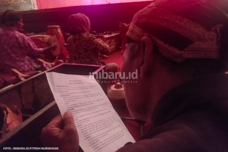 Seorang dalang sedang memperhatikan naskah cerita yang akan dijalankan para pemain wayang orang Ngesti Pandowo.
