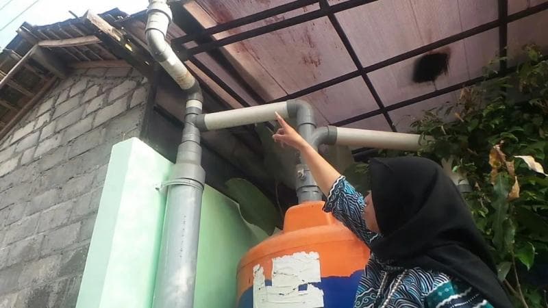 Sri Wahyuningsih menunjukkan wadah penampungan air hujan di rumahnya. (Liputan6/Switzy Sabandar)