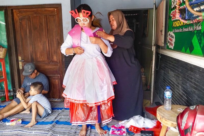 Ningsih terlihat sedang merancang gaun dari bahan dasar sampah yang siap digunakan untuk acara fashion show Hari Ibu bersama para anggota PKK di Kelurahan Bintoro.&nbsp;