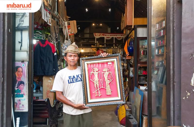 Ahmad Rofiq memegang wayang suket buatannya di Kios Barang Antik Kota Lama Semarang. (Inibaru.id/ Fitroh Nurikhsan)