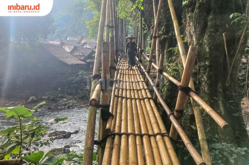 Salah seorang Suku Badui sedang menyembrangi jembatan kayu tanpa alas kaki. (Inibaru.id/ Fitroh Nurikhsan)