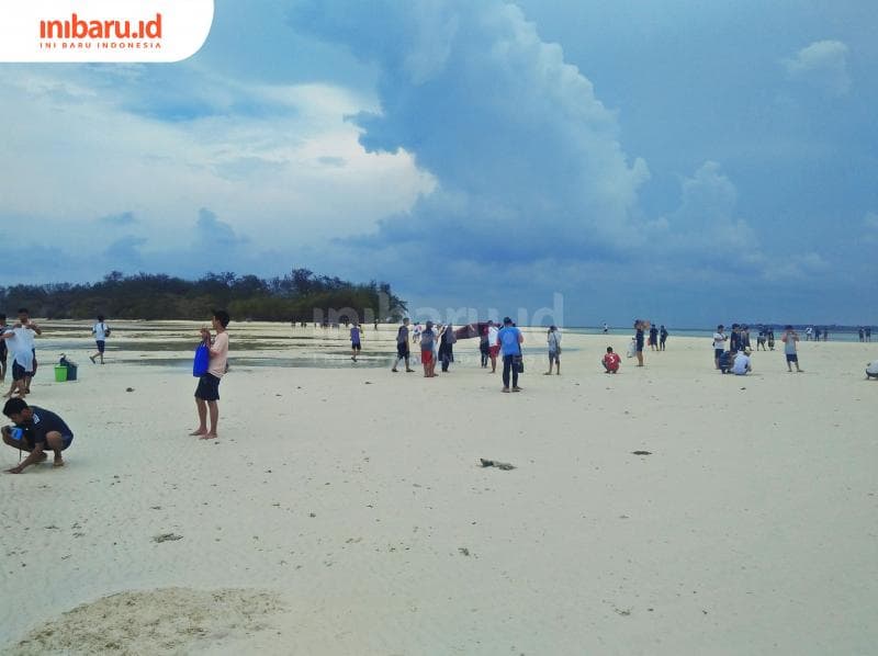 Wisatawan menikmati keindahan hamparan pasir putih di Pulau Cemoro Besar. (Inibaru.id/ Issahani)<br>