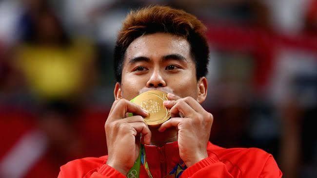 Tontowi Ahmad mencium medali emas. (Twitter/@junedikan)
