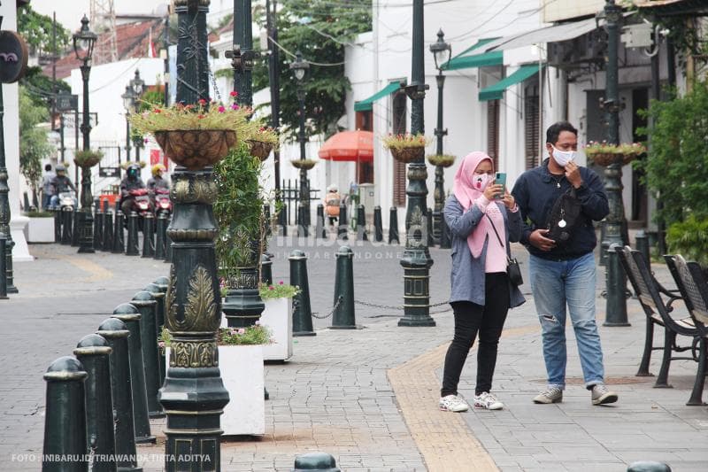 Muda-mudi yang menggunakan masker berswafoto di kawasan Kota Lama pada 28 Mei 2020.