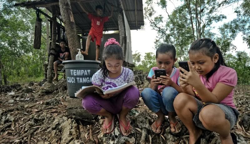 Ilustrasi: Siswa sekolah dasar di Bukit Temulawak, Yogyakarta, mengikuti pembelajaran jarak jauh (PJJ) menggunakan ponsel. Di Indonesia, belajar online bukanlah perkara mudah. (Liputan6/AFP/Agung Supriyanto)