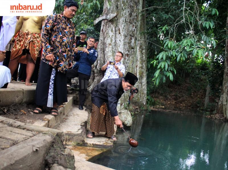 Sesepuh desa wisata Kandri mengambil air dari Sendang Gedhe. (Inibaru.id/ Audrian F)<br>