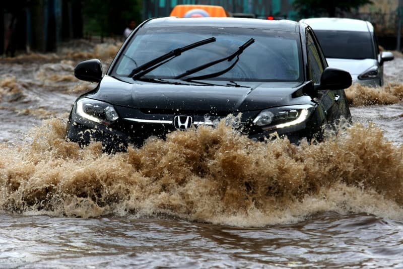 Banjir di berbagai kota besar memaksa banyak mobil menerjang genangan air (Uzone.id)