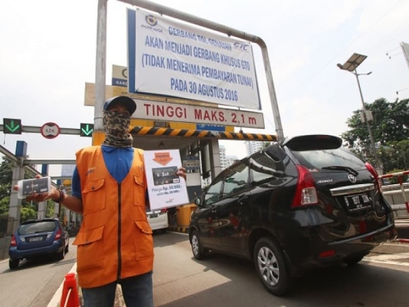 Petugas pintu tol menawarkan kartu e-toll kepada pengemudi kendaraan yang akan memasuki pintu tol. (Rivan Awal Lingga/Antaranews)