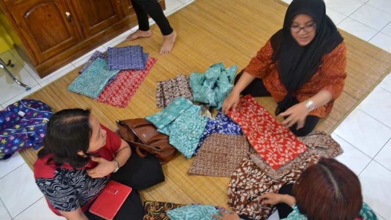 Pencinta batik berdiskusi dengan pengelola toko batik, memilih kain yang akan dibeli. (Liputan6.com/Muhamad Ridlo)