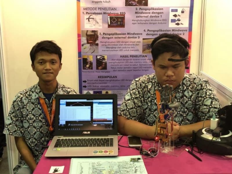 Keyasa Abimanyu Nugroho (kiri) dan Reefo Aththobarani (kanan) sedang memperlihatkan lengan robot ciptaannya pada pameran sains yang berlangsung di Balai Kartini Jakarta. (Beritagar/Ivan)