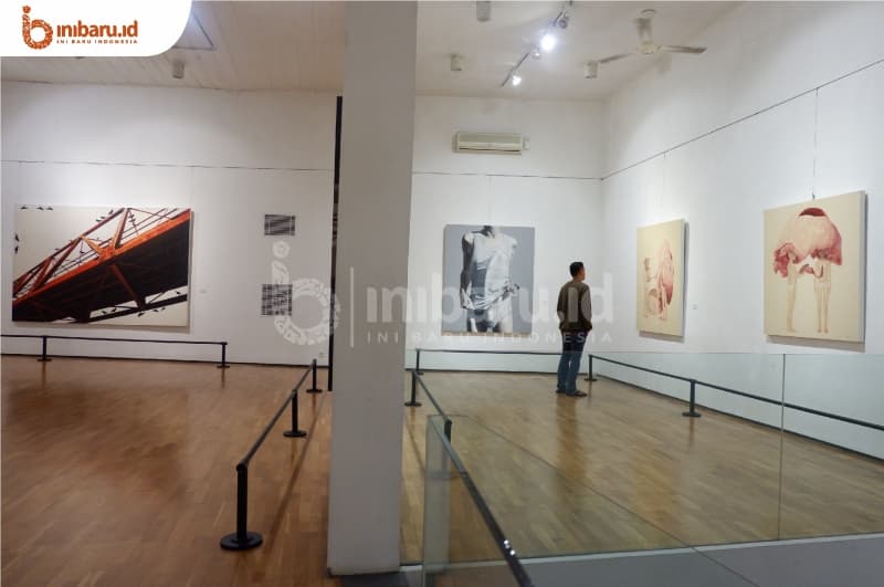 Salah satu pengunjung menikmati karya seni yang ada di Semarang Contemporary Art Gallery. (Inibaru.id/Hayyina Hilal)