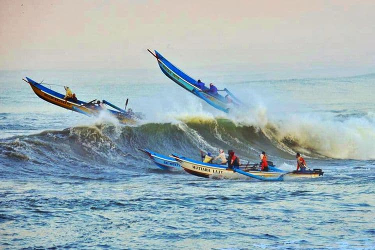 Perahu nelayan menerjang gelombang tinggi di perairan Teluk Penyu, Cilacap, Jawa Tengah. (Kompas.com/Iqbal Fahmi)