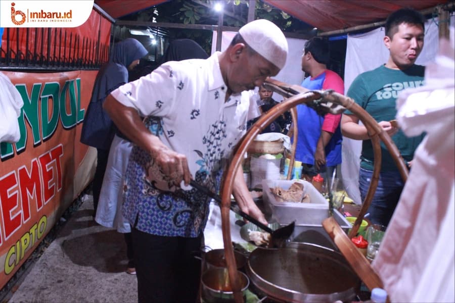Memet, pemilik Nasi Gandul Pak Memet Semarang sedang melayani pelanggannya. (Inibaru.id/ Muhammad Adiatma)
